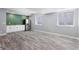 Basement kitchenette with white cabinets, stainless steel refrigerator and LVP flooring at 16069 Pikes Peak Dr, Broomfield, CO 80023