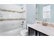 Clean bathroom showcasing a tiled tub, dark wood vanity, and neutral tones, offering a spa-like feel at 16069 Pikes Peak Dr, Broomfield, CO 80023