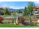 Well-maintained landscaping featuring a wooden fence, lush greenery, colorful flowers, and beautiful mountain views at 16069 Pikes Peak Dr, Broomfield, CO 80023