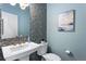Stylish powder room boasting a modern vanity, decorative mirror, and beautiful tiled accent wall at 16069 Pikes Peak Dr, Broomfield, CO 80023