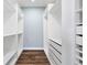 Bright walk-in closet with custom white shelving, drawers, and hardwood floors, offering ample storage at 16069 Pikes Peak Dr, Broomfield, CO 80023