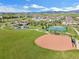 Aerial view of a community park featuring a playground, tennis courts, and a baseball field at 9139 Flora St, Arvada, CO 80005