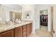 Bathroom featuring double sinks with granite countertops and access to a walk-in closet for ample storage at 9139 Flora St, Arvada, CO 80005