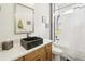 Modern bathroom with a unique black marble sink, white countertop, and a shower-tub combination at 9139 Flora St, Arvada, CO 80005
