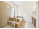 Luxurious bathroom featuring a glass shower enclosure, soaking tub, and modern vanity with beautiful stone countertops at 9139 Flora St, Arvada, CO 80005