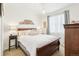 Cozy bedroom featuring a chandelier, white bedding, a wooden headboard, and a dresser for storage at 9139 Flora St, Arvada, CO 80005