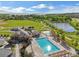 Aerial view of a sparkling pool with sun glinting off of the water, surrounded by trees and grass at 9139 Flora St, Arvada, CO 80005