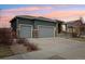Exterior of the home with a two-car garage, stone accents, and professional landscaping at 9139 Flora St, Arvada, CO 80005