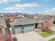 Exterior of a well-maintained home features a three-car garage, stone accents, and manicured landscaping at 9139 Flora St, Arvada, CO 80005