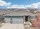 Beautiful two-car garage home featuring stone accents, a spacious driveway, and mountain views at 9139 Flora St, Arvada, CO 80005