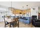 Charming kitchen and dining area featuring an island with seating, a stainless refrigerator, and wood floors at 9139 Flora St, Arvada, CO 80005