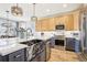 Modern kitchen features an island with a farmhouse sink, stainless steel appliances, and quartz countertops at 9139 Flora St, Arvada, CO 80005