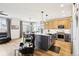 Open kitchen and dining area featuring modern appliances, a large kitchen island, and wood floors at 9139 Flora St, Arvada, CO 80005