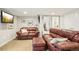 Basement living room with comfortable leather sofas, a TV, and ample space for relaxation and entertainment at 9139 Flora St, Arvada, CO 80005