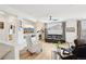 Open living room featuring a stone fireplace, hardwood flooring, neutral paint, and large windows for natural light at 9139 Flora St, Arvada, CO 80005