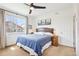Bright primary bedroom with a ceiling fan, mountain artwork, and a large window for ample natural light at 9139 Flora St, Arvada, CO 80005