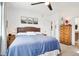 Comfortable primary bedroom with a ceiling fan, mountain artwork, and wood bedside tables with lamps at 9139 Flora St, Arvada, CO 80005