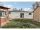 Shot of the grassy backyard showcasing the home's exterior, the red storage shed, and an additional shed in neutral tones at 1540 E 95Th Ave, Thornton, CO 80229