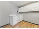 This laundry room has wood floors and white cabinets at 1540 E 95Th Ave, Thornton, CO 80229