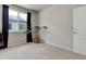 Bedroom featuring neutral walls, carpet, a large window with dark curtains, and a decorative plant at 1310 Hoyt St # 6, Lakewood, CO 80215