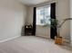 Bedroom featuring neutral walls, carpet, a large window with dark curtains, and a decorative plant at 1310 Hoyt St # 6, Lakewood, CO 80215