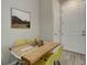 Cozy dining area featuring a wooden table with yellow chairs and a serene mountain view artwork at 1310 Hoyt St # 6, Lakewood, CO 80215