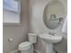 Stylish half bathroom featuring a pedestal sink, round mirror, and modern fixtures at 1310 Hoyt St # 6, Lakewood, CO 80215