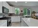 Contemporary kitchen with stainless steel appliances, white cabinets, and a quartz countertop island at 1310 Hoyt St # 6, Lakewood, CO 80215