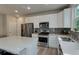 Modern kitchen featuring white cabinets, stainless steel appliances, and gray backsplash at 1310 Hoyt St # 6, Lakewood, CO 80215