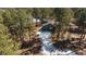 Aerial view of a home surrounded by trees and some snow at 28539 Douglas Park Rd, Evergreen, CO 80439