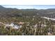 Beautiful aerial of a mountain neighborhood with a canopy of dense pine trees at 28539 Douglas Park Rd, Evergreen, CO 80439