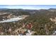 Breathtaking aerial view highlighting the home's location amidst a forest with a frozen lake and snow-capped mountains at 28539 Douglas Park Rd, Evergreen, CO 80439