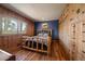 Cozy bedroom featuring wood-paneled walls, hardwood floors, and a closet for ample storage at 28539 Douglas Park Rd, Evergreen, CO 80439