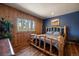 Inviting bedroom featuring hardwood floors, wood-paneled walls, and large windows with a scenic view at 28539 Douglas Park Rd, Evergreen, CO 80439