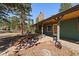 Inviting covered porch featuring a stone chimney and rustic decor elements, creating a cozy outdoor space at 28539 Douglas Park Rd, Evergreen, CO 80439