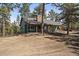 Charming home with a stone chimney and covered porch nestled among mature trees at 28539 Douglas Park Rd, Evergreen, CO 80439
