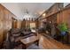 Cozy living room features a stone fireplace, wood paneling, and hardwood floors at 28539 Douglas Park Rd, Evergreen, CO 80439
