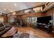 Spacious living room features wood-paneled walls, a stone fireplace, and hardwood floors at 28539 Douglas Park Rd, Evergreen, CO 80439