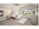 A spacious bedroom is showcased with a fireplace, large windows, and sleek grey toned decor at 9467 W Plymouth Ave, Littleton, CO 80128