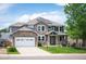 Charming two-story home featuring stone accents, a well-manicured lawn, and solar panels at 9467 W Plymouth Ave, Littleton, CO 80128