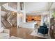 Open-concept living room with hardwood floors, fireplace, and adjacent kitchen with modern appliances and a breakfast bar at 9467 W Plymouth Ave, Littleton, CO 80128