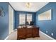 Home office with a large wooden desk, blue walls, and natural light, providing a productive workspace at 9467 W Plymouth Ave, Littleton, CO 80128