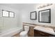 Well-lit bathroom features tile accents, a bathtub/shower combo, and a vanity sink at 14190 E Gunnison Pl, Aurora, CO 80012