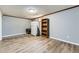 A cozy basement space with wood-look flooring, featuring storage, a refrigerator and natural light from a window at 15645 E Floyd Ave, Aurora, CO 80013