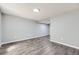 A spacious finished basement area with wood-look flooring, neutral gray walls, and recessed lighting at 15645 E Floyd Ave, Aurora, CO 80013