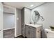 Nicely finished bathroom with modern vanity, storage, and a round mirror at 15645 E Floyd Ave, Aurora, CO 80013