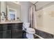 Well-maintained bathroom with a shower-tub combo, dark vanity, and neutral decor at 15645 E Floyd Ave, Aurora, CO 80013