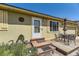 Close up view of the ranch home entrance with a small porch, chairs, and a table at 15645 E Floyd Ave, Aurora, CO 80013