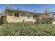 Ranch style home with charming yellow paint, nice landscaping, and solar panels on the roof at 15645 E Floyd Ave, Aurora, CO 80013