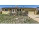 Ranch style home with solar panels, two-car garage, and front yard with mature bushes at 15645 E Floyd Ave, Aurora, CO 80013
